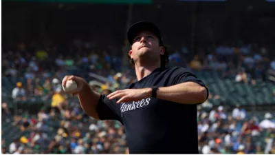 New York Yankees' Gerrit Cole throws a foul ball over the net into the stands during a game against Oakland Athletics at RingCentral Coliseum. Oakland^ California - August 28^ 2021