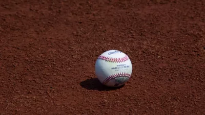 used Major League Baseball baseball sits on the warning track during a game between the Oakland Athletics and New York Yankees at RingCentral Coliseum. Oakland^ California - August 28^ 2021