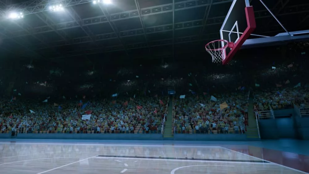 empty basketball court; shot of hoop and crowd in background