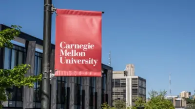 Carnegie Mellon University campus entrance sign with buildings in the background. Pittsburgh^ Pennsylvania^ USA- May 13^ 2021: Carnegie Mellon University campus entrance sign with buildings in the background. CMU is a private research university