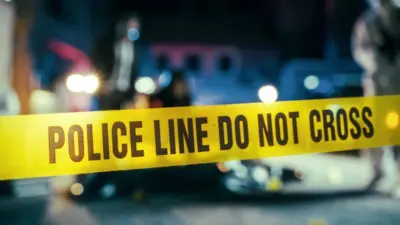 Yellow Tape Showing Text "Police Line Do Not Cross" Restricting a Crime Scene Area At Night. Close Up Aesthetic Shot with Bokeh Effect and Flickering Lights. Criminal on the Loose Strikes Again