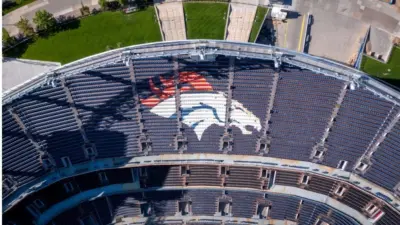Denver Broncos Logo in Empty Stadium Seats at Empower Field. Aerial Top-Down View of NFL Branding and Architecture in Denver^ Colorado ay 26^ 2022 Denver^ Colorado