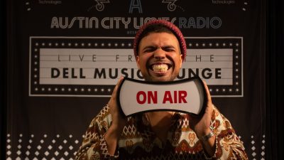 Devon Gilfillian holding "on air" sign