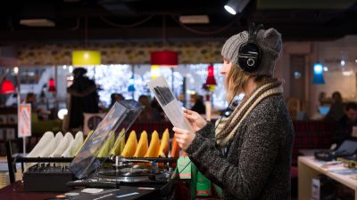 Woman listening to records in record store