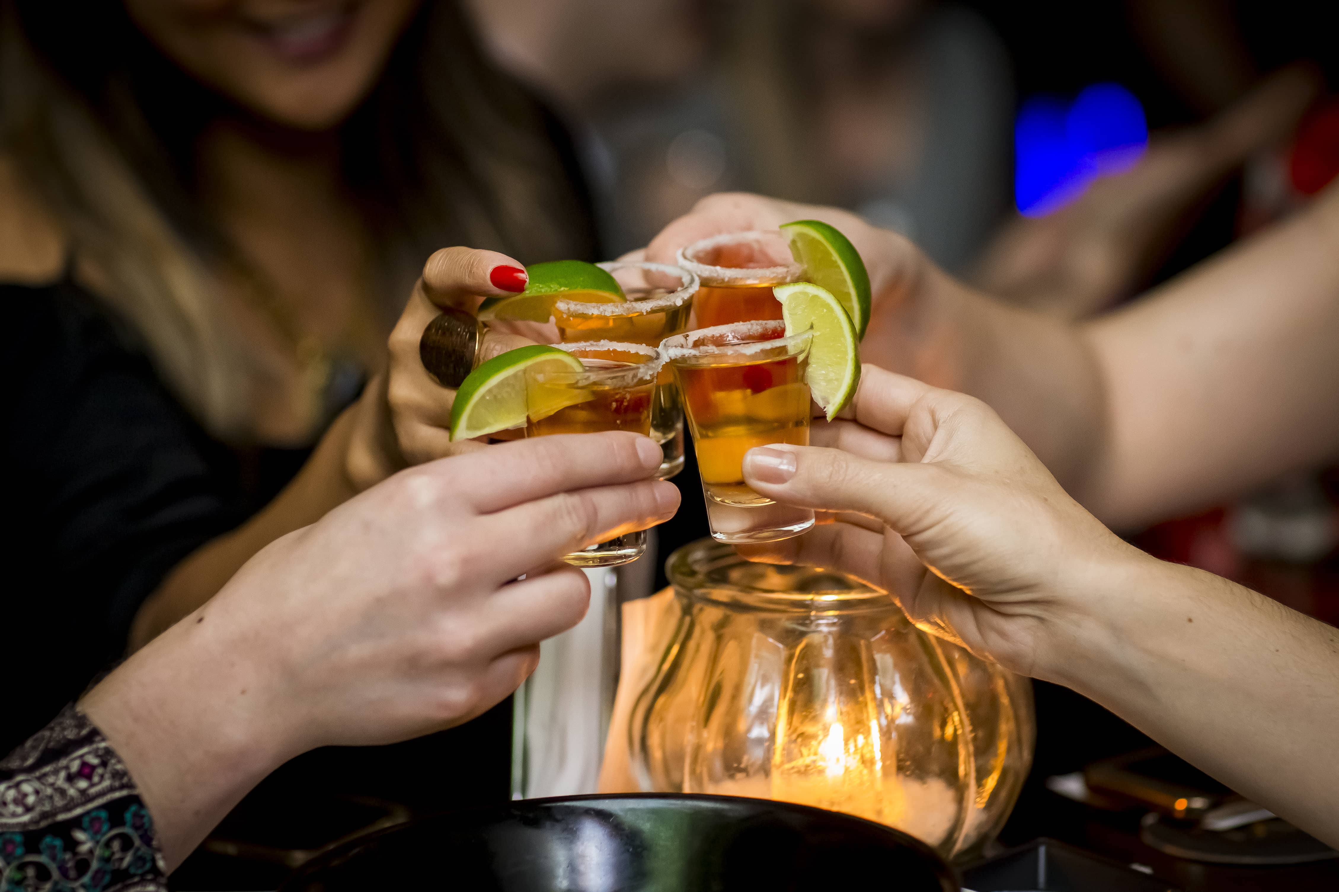 Girls making a toast with tequila shots.