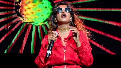 M.I.A performing on stage with a red jumpsuit