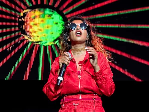 M.I.A performing on stage with a red jumpsuit