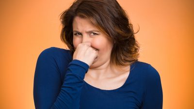 A lady holding her nose.