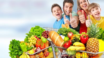 Shutterstock image of a family in the grocery store with thumbs up and a cart full of groceries.