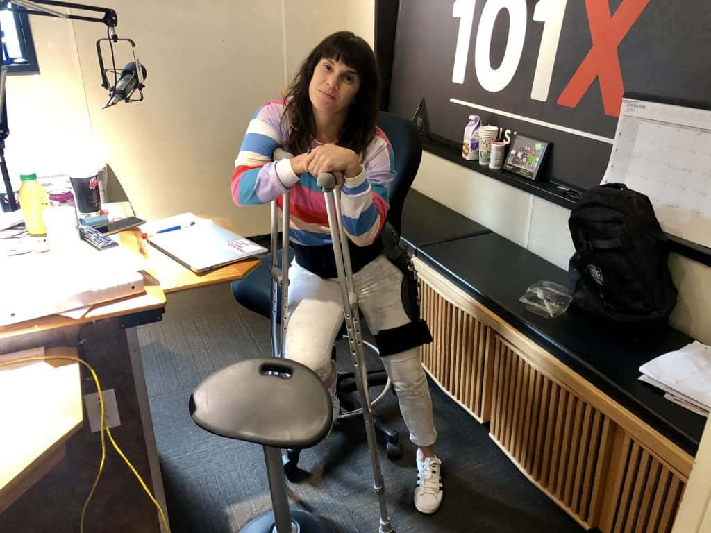 Deb with crutches and her leg brace in the studio.