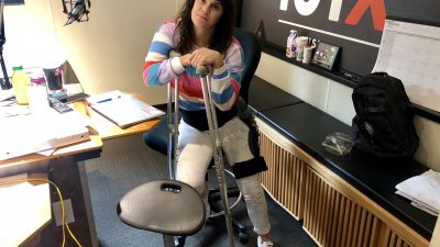 Deb with crutches and her leg brace in the studio.