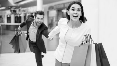Lady and man running with shopping bags.