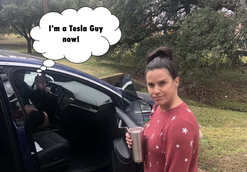 Deb looking upset at Jason while he is in his new Tesla.