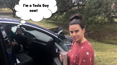 Deb looking upset at Jason while he is in his new Tesla.