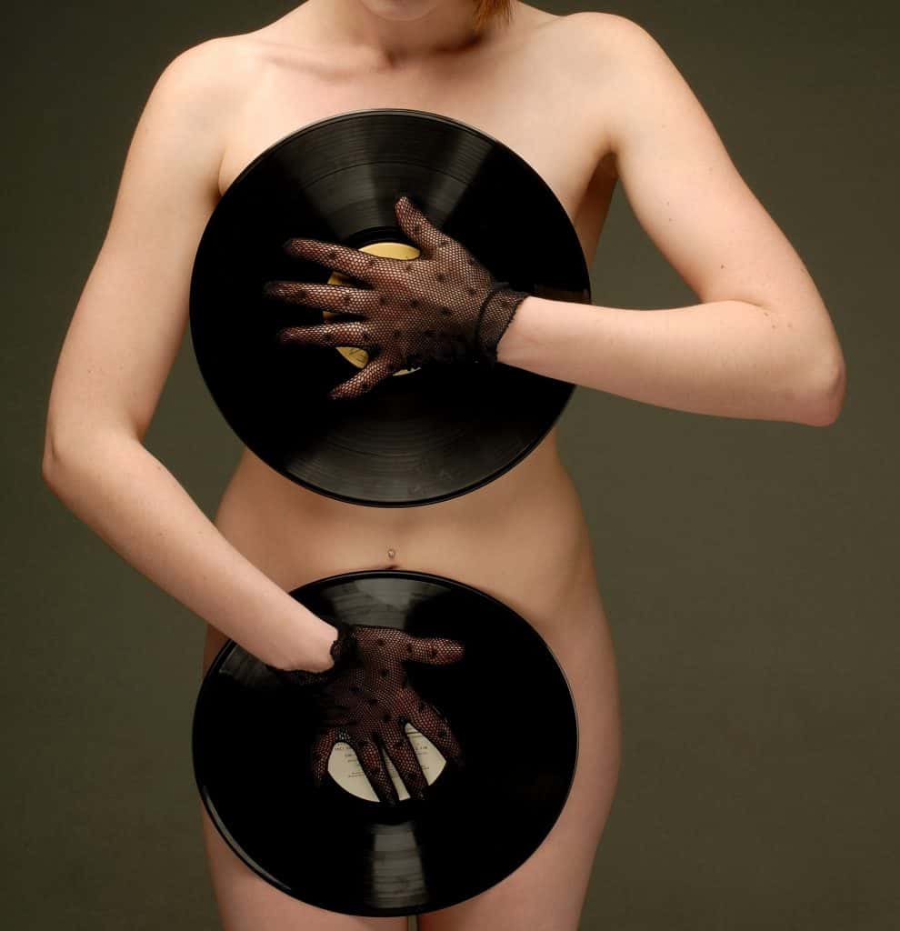 Shutter stock image of a naked lady covering herself up with records.