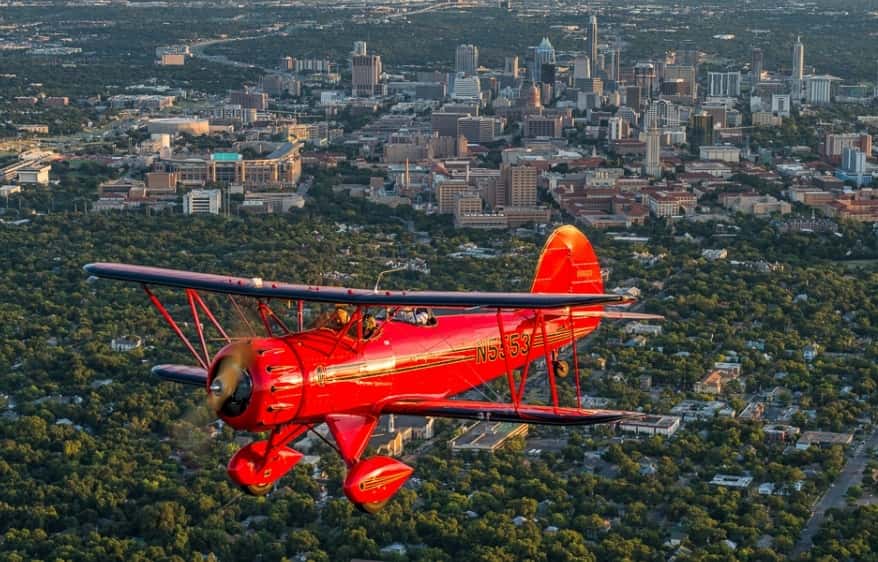 The biplane from Austin Biplanes flying over downtown Austin