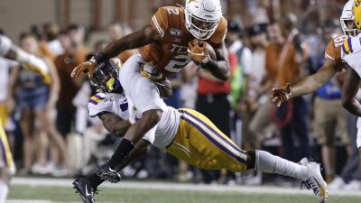 UT longhorn getting tackled by a LSU Tiger