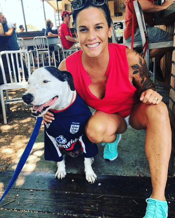 Image of Deb and Blue in a Bar with red shirt to represent England and a dog jersey for blue