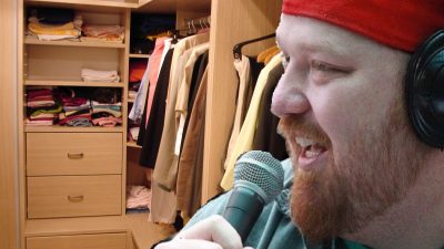 Jason in the closet with a microphone and headphones.
