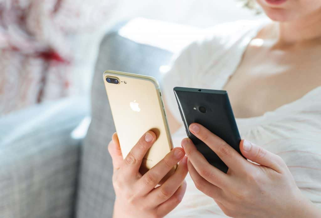 A lady looking at an iPhone and Android.