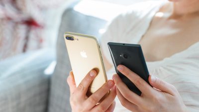 A lady looking at an iPhone and Android.