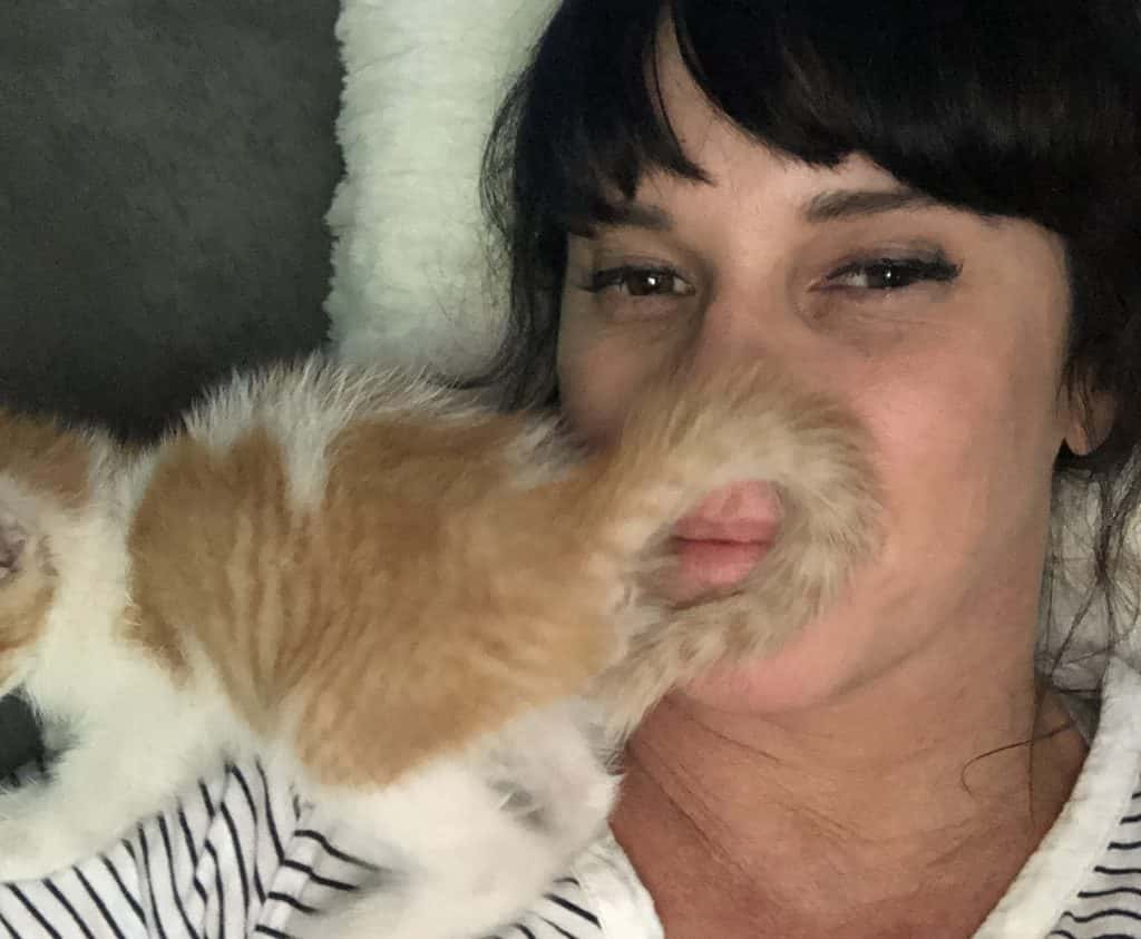 Deb with her new cat on her face.