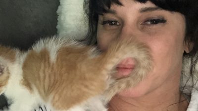 Deb with her new cat on her face.