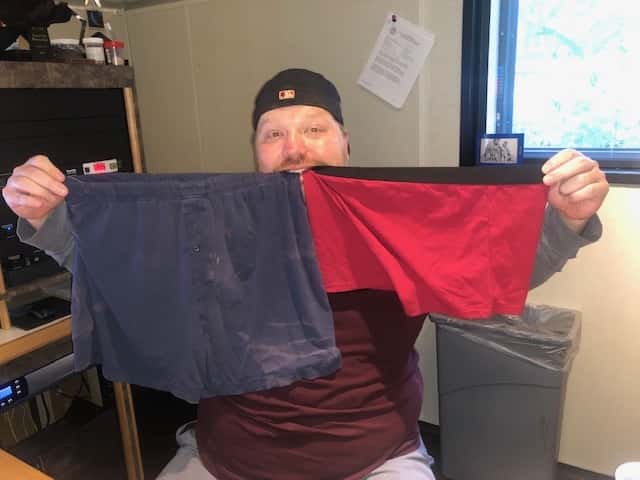 Jason holding up two versions of underpants.