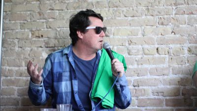 Doug Benson with a green shirt over his arms at the Jason and Deb St. Patty's day broadcast at King Fu.