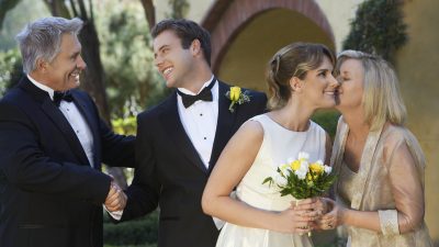Groom and father of the bide talking along side bride and mother of the bride