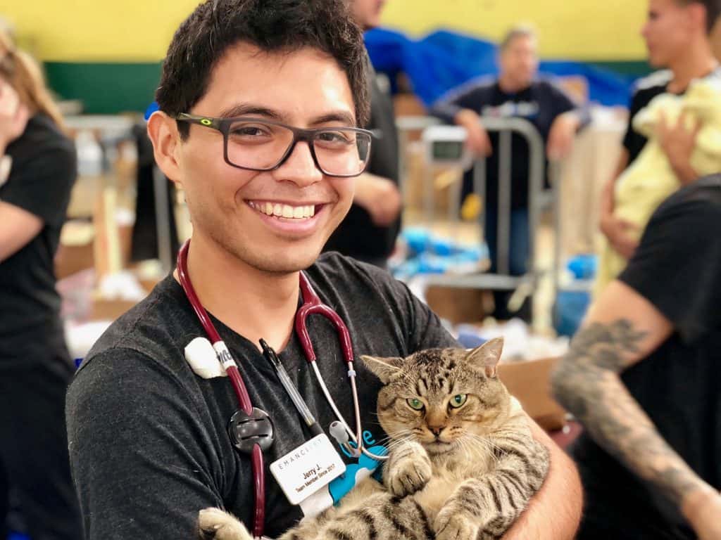 An Emancipet employee holding a cat at the mobile clinic.