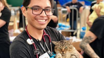 An Emancipet employee holding a cat at the mobile clinic.