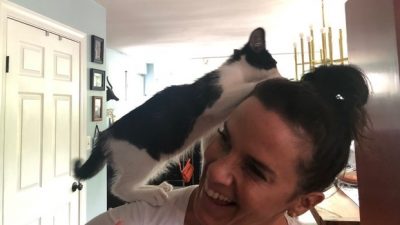 Deb's cat George climbing on her shoulder.