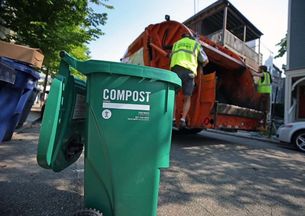 compost bin with garbage man behind loading truck