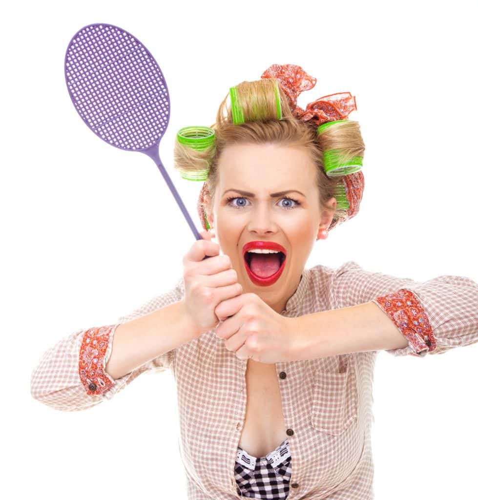 A lady with rollers holding a fly swatter.