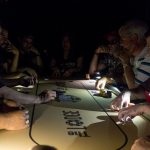 Beat The Dick Poker Tournament : poker players in the dark, using their phones to light the table