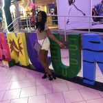 Producer Imari's Trip To Cancun: Producer Imari in front of a Cancun sign. 