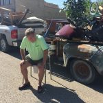Trash Day In Granger, Texas: a man sitting on a portable toilet designed for the elderly