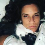 Memories Of George: Deb and her cat George laying in the bed with him around her neck. 