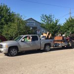 Trash Day In Granger, Texas: A trailer full of trash hitched to a pick up truck with trash in the bed