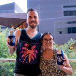 101X Concert Series Ft. RÜFÜS DU SOL: Couple Posing with We Are blood koozies
