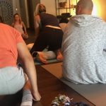 Puppy Yoga :  A group of people doing puppy yoga in a class. 