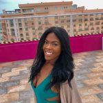 Producer Imari's Trip To Cancun : Producer Imari at a hotel rooftop pool in front of a building. 