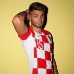 Dulje Ćaleta-Car: Croatia Defender: Dulje Ćaleta-Car: Croatia Defender with his arm over his head in front of a yellow wall. 