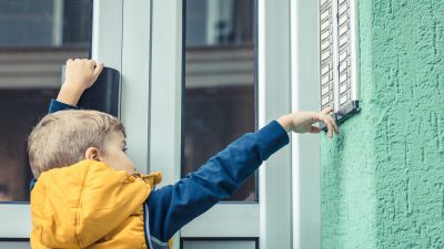 A kid ringing doorbell and knocking door.