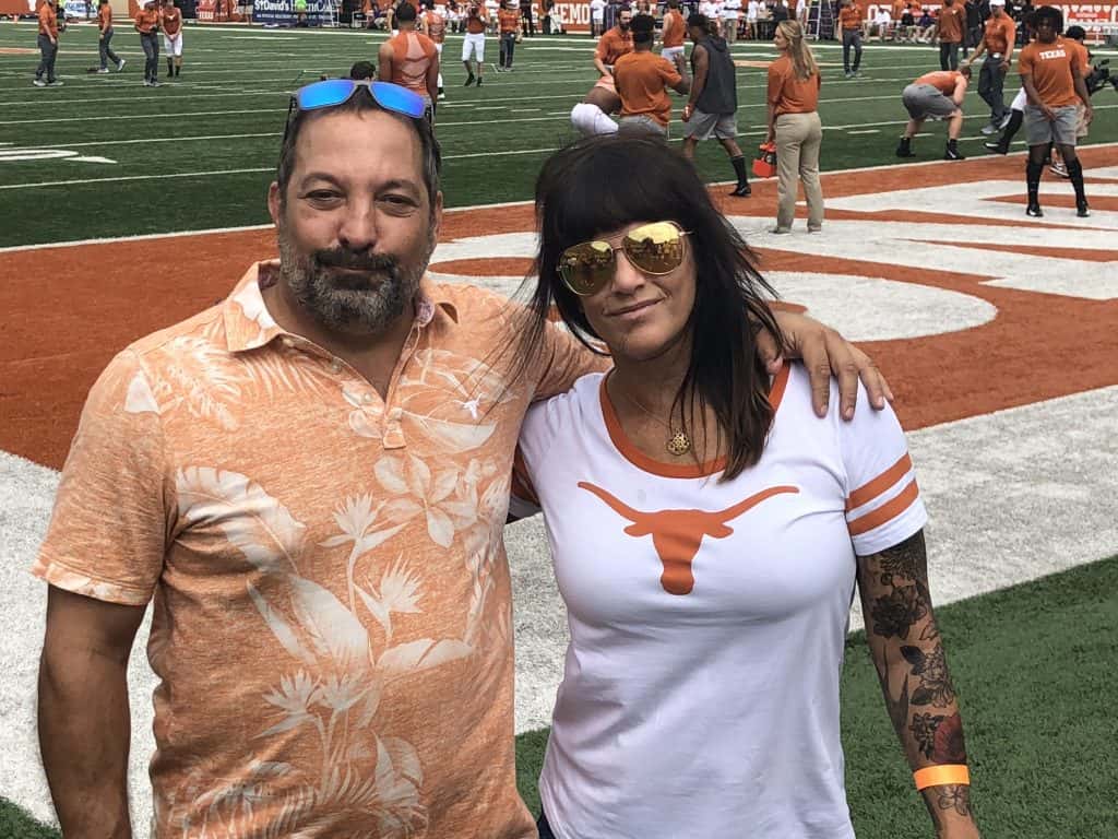 Deb and her friend Randy at the game in front of the Longhorn field