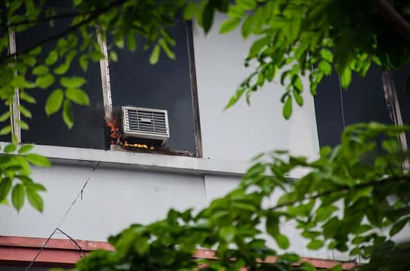 Getty image of Air conditioning unit on fire outside of a building