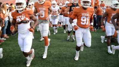 University of Texas Longhorns football team in uniform running onto the field