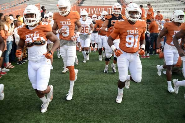 University of Texas Longhorns football team in uniform running onto the field