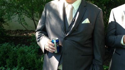 Jason in a suit with a beer.